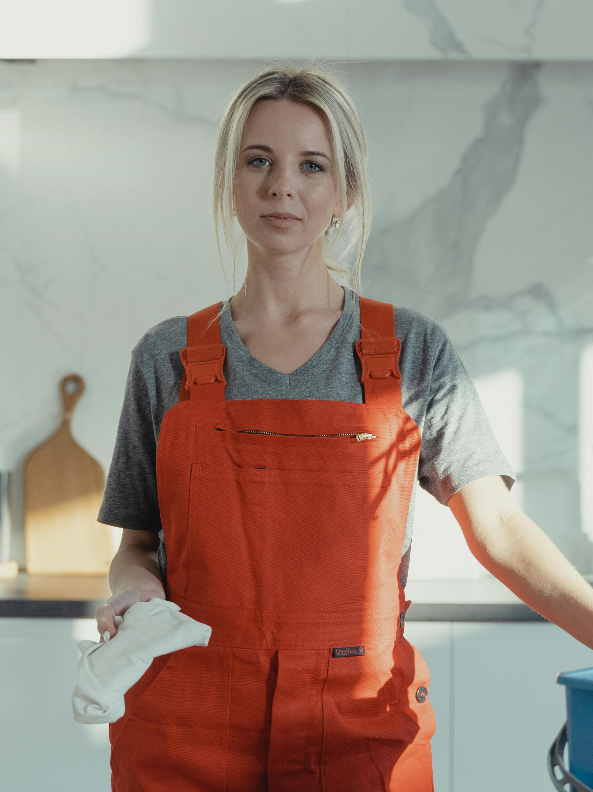 Wohnungsreinigung in der Küche – Karl & Olaf Reinigungskraft hält Tuch in der Küche für die Reinigung